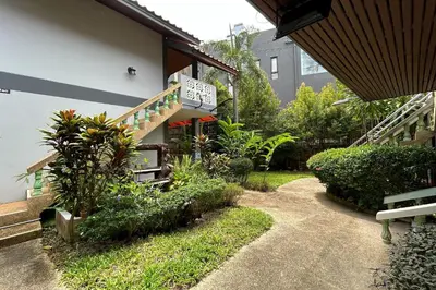 a garden with plants and a building with a staircase at Me Mee Place & Tour Krabi in Ao Nang Beach