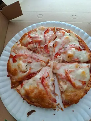 a white paper plate with a pizza on it at Big Hug Home in Ko Yao Noi