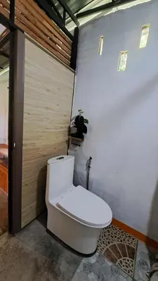 a bathroom with a toilet in a room at Big Hug Home in Ko Yao Noi