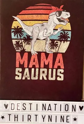 a book with a picture of a dinosaur on a beach at Destination39 in Thalang