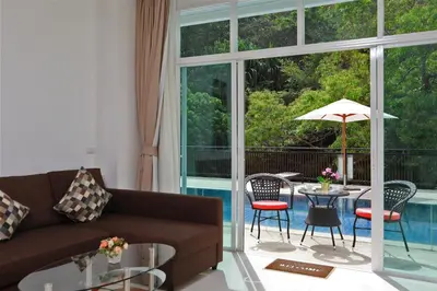 a living room with a couch and a table with an umbrella at Suite Cascade 2BR Family Deluxe Kamala Falls in Kamala Beach