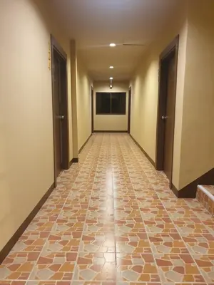 an empty hallway with a tile floor and two doors at My Friend's House Karon in Karon Beach