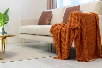 an orange blanket on a couch in a living room at Bangla house with 4 houses Pick house before BOOK in Patong Beach