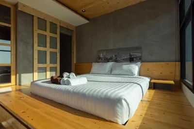 a bedroom with a large bed with white sheets at Sara's Nest - Top Floor Seaview apartments in Nai Harn Beach