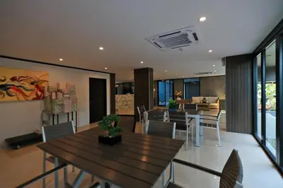 a dining room with a wooden table and chairs at Sara's Nest - Top Floor Seaview apartments in Nai Harn Beach
