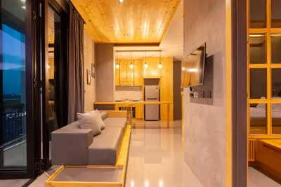 a living room with a couch and a kitchen at Sara's Nest - Top Floor Seaview apartments in Nai Harn Beach