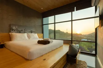 a bedroom with a large bed and a large window at Sara's Nest - Top Floor Seaview apartments in Nai Harn Beach