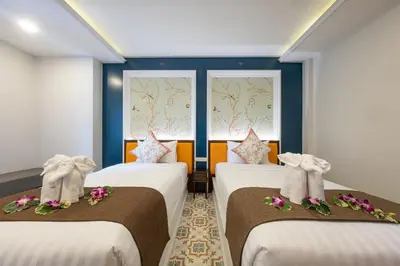 two beds in a room with two windows at Sino Siam Hotel in Klong Muang Beach