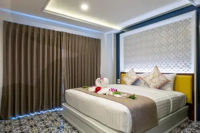 a bedroom with a large bed with flowers on it at Sino Siam Hotel in Klong Muang Beach