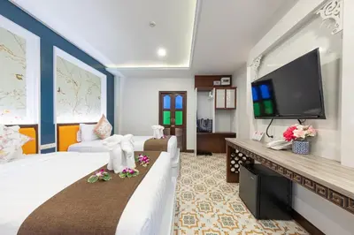 a hotel room with a bed and a flat screen tv at Sino Siam Hotel in Klong Muang Beach