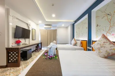 a hotel room with a bed and a tv at Sino Siam Hotel in Klong Muang Beach