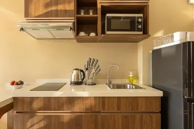 a kitchen with a sink and a refrigerator at NaiHarn Sea Condo by Holy Cow, 1-BR, mountain view in Nai Harn Beach