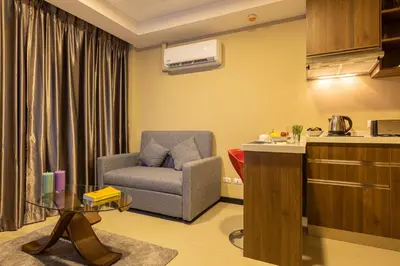 a living room with a chair and a table at NaiHarn Sea Condo by Holy Cow, 1-BR, mountain view in Nai Harn Beach