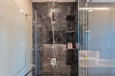a bathroom with a shower with a glass door at Panora Surin by Holy Cow, 1-BR, courtyard view in Surin Beach