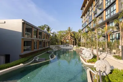 a swimming pool in front of a building at Panora Surin by Holy Cow, 1-BR, courtyard view in Surin Beach