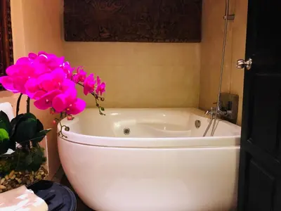a white bath tub with pink flowers in a bathroom at Baipho Lifestyle in Patong Beach
