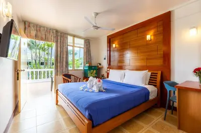 a bedroom with two cats sitting on a bed at The Expat Hotel Patong in Patong Beach