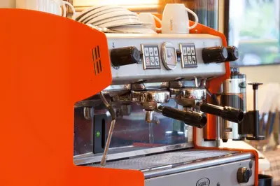an orange espresso machine sitting in a kitchen at The Expat Hotel Patong in Patong Beach