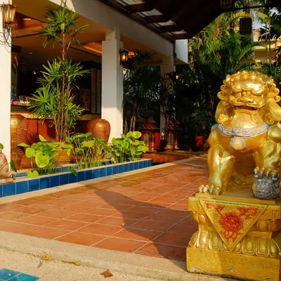 a gold lion statue sitting in front of a building at The Expat Hotel Patong in Patong Beach