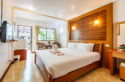 a bedroom with a bed with a stuffed animal on it at The Expat Hotel Patong in Patong Beach