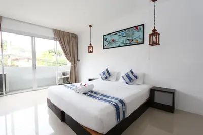 a bedroom with a large bed and a large window at The Nest Resort Patong in Patong Beach