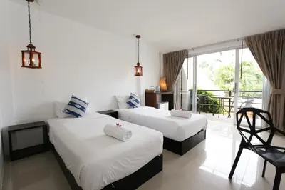 two beds in a room with a balcony at The Nest Resort Patong in Patong Beach