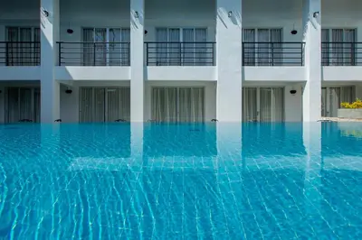 a swimming pool in front of a building at The Nest Resort Patong in Patong Beach