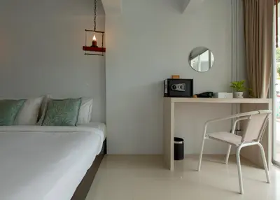 a bedroom with a bed and a desk and a chair at The Nest Resort Patong in Patong Beach