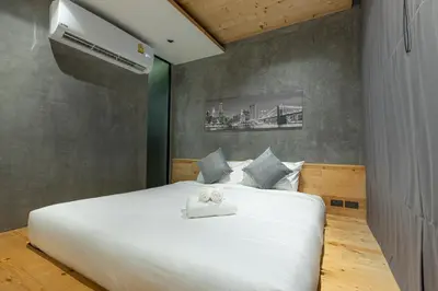 a bedroom with a white bed and a air conditioner at Relife Windy by Holy Cow, courtyard view in Nai Harn Beach