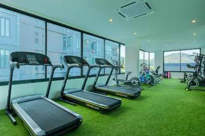 a gym with several treadmills and exercise bikes at Relife Windy by Holy Cow, courtyard view in Nai Harn Beach
