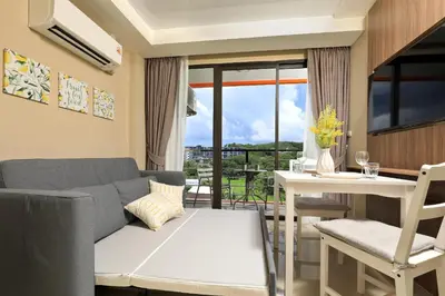 a living room with a couch and a table at NaiHarn Sea Condo, Top floor, Mountain View in Nai Harn Beach