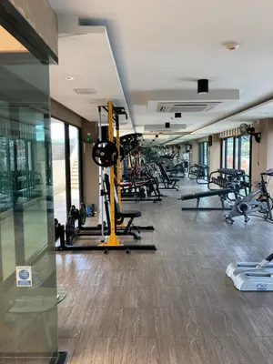 a gym with a lot of treadmills and machines at Aristo Resort Surin Beach K5 in Phuket Town