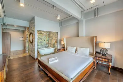 a bedroom with a bed and a bath tub at SHIN Arch39 Phuket Beach Front - SHA Plus in Chalong