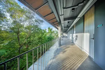 a balcony of a building with trees in the background at SHIN Arch39 Phuket Beach Front - SHA Plus in Chalong