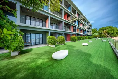 a building with a green yard with white objects on it at SHIN Arch39 Phuket Beach Front - SHA Plus in Chalong