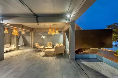 a covered patio with a couch and chairs and lights at SHIN Arch39 Phuket Beach Front - SHA Plus in Chalong