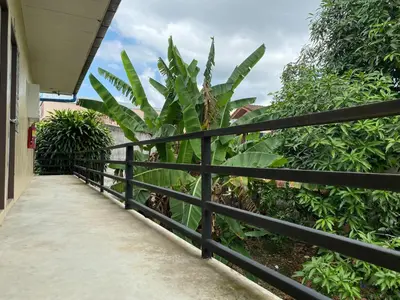 a black fence with a walkway next to some plants at Andaman Place in Thalang