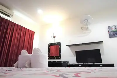 a bedroom with a bed and a flat screen tv at Andaman Place in Thalang