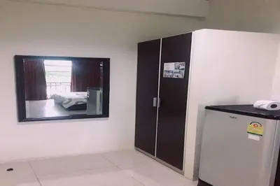 a room with a mirror and a refrigerator in it at Andaman Place in Thalang