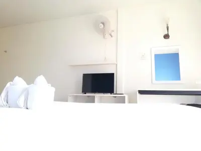 a white room with a television and a microwave at Andaman Place in Thalang