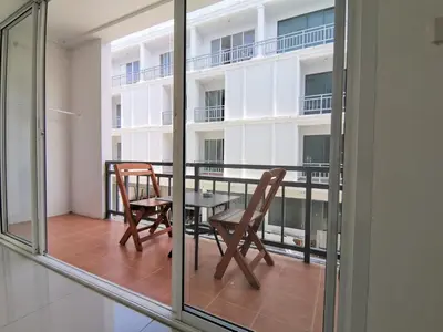 a balcony with a table and chairs and a building at Sure Guesthouse in Kamala Beach