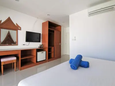a living room with a tv and a blue couch at Sure Guesthouse in Kamala Beach