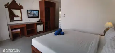 a bedroom with a bed with a blue stuffed animal on it at Sure Guesthouse in Kamala Beach