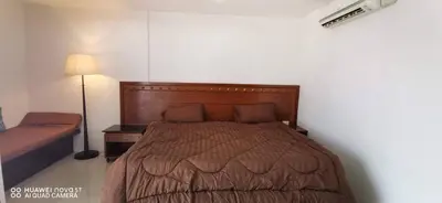 a bedroom with a large bed with a wooden headboard at Sure Guesthouse in Kamala Beach
