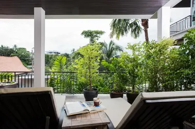 a patio with a table and chairs and trees at Kata gardens 2 bedroom near Kata beach 3B in Kata Beach