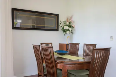a dining room table with chairs and a vase of flowers at Kata gardens 2 bedroom near Kata beach 3B in Kata Beach