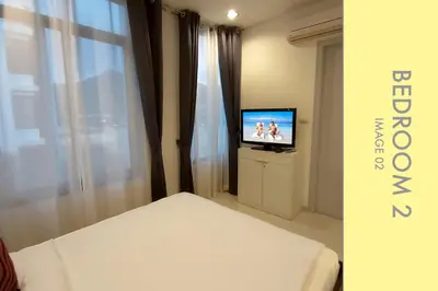 a hotel room with a bed and a television at Stylish Condo Stunning Views in Kamala Beach