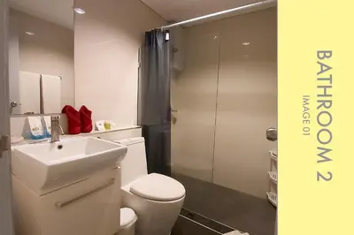 a bathroom with a toilet and a sink and a shower at Stylish Condo Stunning Views in Kamala Beach