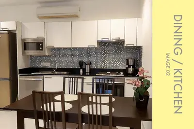 a kitchen with white cabinets and a table and chairs at Stylish Condo Stunning Views in Kamala Beach