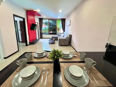 a living room with a table with plates and silverware at NBC Condo, 2-BR, NaiHarn Beach in Nai Harn Beach